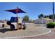 Community playground with blue and orange play structure, swing set, and well-maintained landscaping at 4815 Palacio Ct, Las Vegas, NV 89122