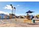 Community playground featuring a play structure, swings, benches, and desert landscaping at 4815 Palacio Ct, Las Vegas, NV 89122