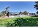 Community pool area surrounded by a wrought iron fence, lush green lawn, and scattered landscaping at 4815 Palacio Ct, Las Vegas, NV 89122