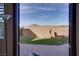 A view of the backyard with desert landscaping and artificial grass from the interior of the house at 500 Via Stretto Ave, Henderson, NV 89011