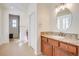 Bright bathroom featuring a wooden vanity with granite countertop and tile flooring at 500 Via Stretto Ave, Henderson, NV 89011