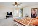 Spacious bedroom featuring neutral carpet, a ceiling fan, and sliding door access to a balcony at 500 Via Stretto Ave, Henderson, NV 89011