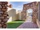 Private courtyard with stone archway, iron gate, and artificial turf at 500 Via Stretto Ave, Henderson, NV 89011