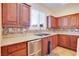 This kitchen features wood cabinets, granite counters, stainless steel appliances, and tile backsplash at 500 Via Stretto Ave, Henderson, NV 89011