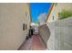 Brick pathway leads to a gated side yard with gravel and a bicycle at 5205 Mantua Ct, Las Vegas, NV 89130