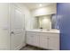 Bathroom with a vanity, white cabinets, and a large mirror at 546 Foothill Cove Ln, Henderson, NV 89002