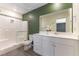 Modern bathroom featuring a glass-enclosed shower, white vanity with sink, and olive accent wall at 546 Foothill Cove Ln, Henderson, NV 89002