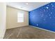 Bedroom with moon and star blue accent wall, and a large window at 546 Foothill Cove Ln, Henderson, NV 89002