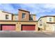 Townhome exterior featuring private garages, a contemporary facade, and a well-maintained street at 546 Foothill Cove Ln, Henderson, NV 89002