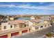 Exterior elevation featuring multi-colored townhomes with attached garages, and mountain views in the distance at 546 Foothill Cove Ln, Henderson, NV 89002