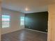 Modern living room with wood-look vinyl plank flooring, two bright windows and an accent wall at 546 Foothill Cove Ln, Henderson, NV 89002