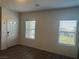 Bright living room featuring two windows, a white entry door, and wood-look vinyl plank flooring at 546 Foothill Cove Ln, Henderson, NV 89002