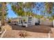 Backyard with a covered patio, seating area, and desert landscaping under a clear blue sky at 6086 Shadow Oak Dr, North Las Vegas, NV 89031