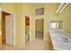 Bright bathroom featuring double sinks, a large mirror and access to a closet and toilet area at 6086 Shadow Oak Dr, North Las Vegas, NV 89031