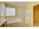 Well-lit bathroom with tub, glass-enclosed shower, and view into walk-in closet with shelving at 6086 Shadow Oak Dr, North Las Vegas, NV 89031