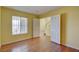 Bright bedroom featuring hardwood floors, a window, and an adjacent room at 6086 Shadow Oak Dr, North Las Vegas, NV 89031