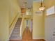 Hallway with wood floors, staircase, and access to rooms, painted with yellow color at 6086 Shadow Oak Dr, North Las Vegas, NV 89031