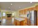 Modern kitchen equipped with stainless steel appliances and a functional island, opening into a spacious living area at 6086 Shadow Oak Dr, North Las Vegas, NV 89031