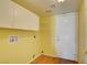 Bright laundry room provides ample storage with upper cabinets and functional shelving for organization at 6086 Shadow Oak Dr, North Las Vegas, NV 89031