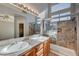 Main bathroom with double vanity, frameless shower, and tile flooring at 6425 Mountain Mesa Ave, Las Vegas, NV 89156