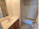 This bathroom features a sink vanity, tiled floors, and tub with shower at 6448 Elwood Mead Ave # 103, Las Vegas, NV 89156