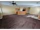 Large open living area with carpet, fan, and kitchen access at 6448 Elwood Mead Ave # 103, Las Vegas, NV 89156