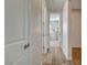 Hallway with wood floors leading to a room with a modern floor lamp at 6544 Sandero Springs St, Las Vegas, NV 89166