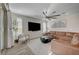 Bright living room featuring a large brown leather sectional and a modern ceiling fan at 6544 Sandero Springs St, Las Vegas, NV 89166