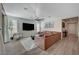 Bright living room featuring a large brown leather sectional and a modern ceiling fan at 6544 Sandero Springs St, Las Vegas, NV 89166