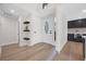 Bright entryway with wood floors, leading to a modern kitchen with black cabinets at 6961 Emerald Springs Ln, Las Vegas, NV 89113