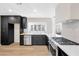 This kitchen features stainless steel appliances, light wood floors, and modern dark custom cabinets at 6961 Emerald Springs Ln, Las Vegas, NV 89113