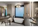 Luxurious bathroom featuring a freestanding tub, elegant chandelier, and modern fixtures at 709 Dragon Peak Dr, Henderson, NV 89012