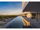 Modern home's infinity pool overlooking mountains features lounge chairs and sleek architectural design at 709 Dragon Peak Dr, Henderson, NV 89012