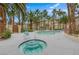 Community pool and hot tub surrounded by palm trees and lounge chairs at 7135 S Durango Dr # 209, Las Vegas, NV 89113