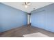 Empty blue bedroom with wall to wall carpet, ceiling fan and closet at 720 Sam Jonas Dr, Las Vegas, NV 89145