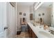 Well-lit bathroom features a double sink vanity with brown cabinetry and tiled floors at 7321 Aspire Ct, Las Vegas, NV 89113