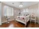 Bright bedroom featuring wood floors, a comfortable bed, large windows, and stylish furnishings at 7321 Aspire Ct, Las Vegas, NV 89113