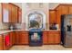 Well-lit kitchen featuring wood cabinets, granite countertops, and a modern black range at 7321 Aspire Ct, Las Vegas, NV 89113