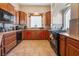 Well-equipped kitchen featuring wood cabinetry, tile floors, and modern appliances at 7321 Aspire Ct, Las Vegas, NV 89113