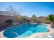 Freeform swimming pool with a waterfall feature and landscaping at 7435 Sun Summit Ct, Las Vegas, NV 89178