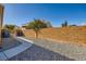 Backyard with gravel, walkway, and block wall at 7666 Rainbow Cove Dr, Las Vegas, NV 89131