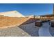 Desert landscaping with covered patio and block wall at 7666 Rainbow Cove Dr, Las Vegas, NV 89131