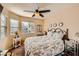 Cozy bedroom with a floral comforter, ceiling fan, and ample natural light at 7666 Rainbow Cove Dr, Las Vegas, NV 89131