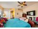 Bright bedroom with a queen bed, ensuite bathroom access, and ceiling fan at 7666 Rainbow Cove Dr, Las Vegas, NV 89131