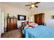 Spacious bedroom with large bed, dresser, and ceiling fan at 7666 Rainbow Cove Dr, Las Vegas, NV 89131