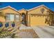 House exterior with a two-car garage and desert landscaping at 7666 Rainbow Cove Dr, Las Vegas, NV 89131