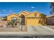 One-story house with a two-car garage and desert landscaping at 7666 Rainbow Cove Dr, Las Vegas, NV 89131