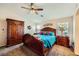 Main bedroom with ceiling fan, large bed, and an ensuite bathroom at 7666 Rainbow Cove Dr, Las Vegas, NV 89131