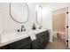 Bathroom with double vanity, white countertops, black cabinets, and a view of the bathtub at 7695 Silver Wells Rd, Las Vegas, NV 89149