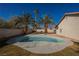 Backyard with a classic pool, mature palm trees, a desert landscaped yard, and clear blue sky at 7695 Silver Wells Rd, Las Vegas, NV 89149